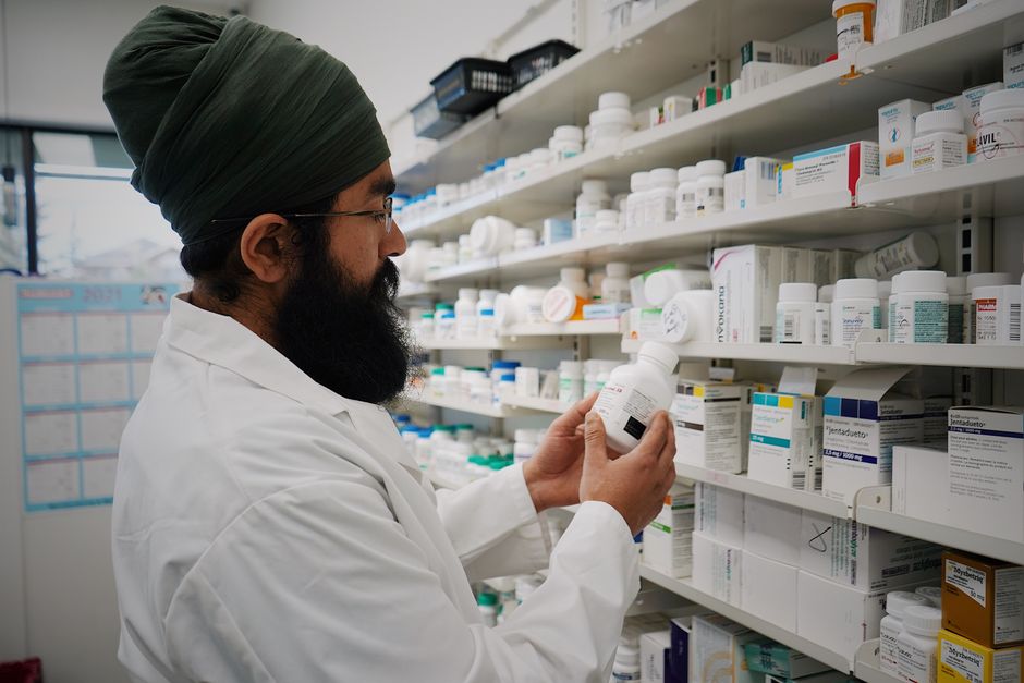 Farmacêutico organizando prateleiras de medicamentos em uma farmácia