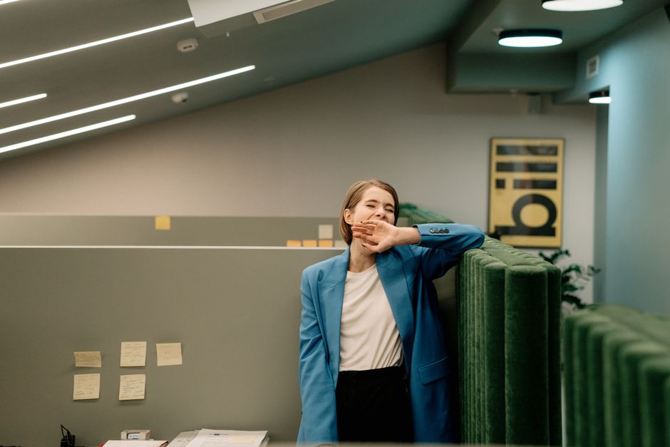 Mulher exausta bocejando durante o expediente no escritório